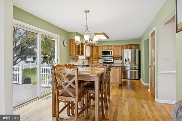 a view of a dining room and livingroom with furniture wooden floor a chandelier