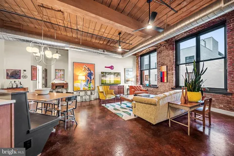 a living room with furniture a wooden floor and a large window