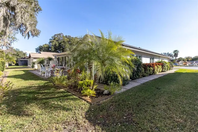 a view of a backyard with plants and chairs