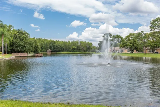 a front view of a building with a garden and trees