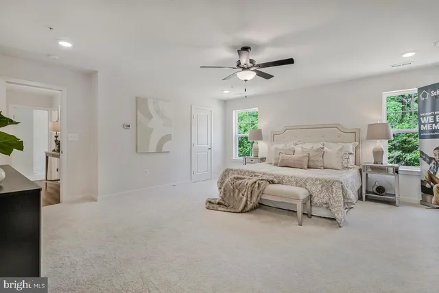 a spacious bedroom with a bed a couch and a chandelier