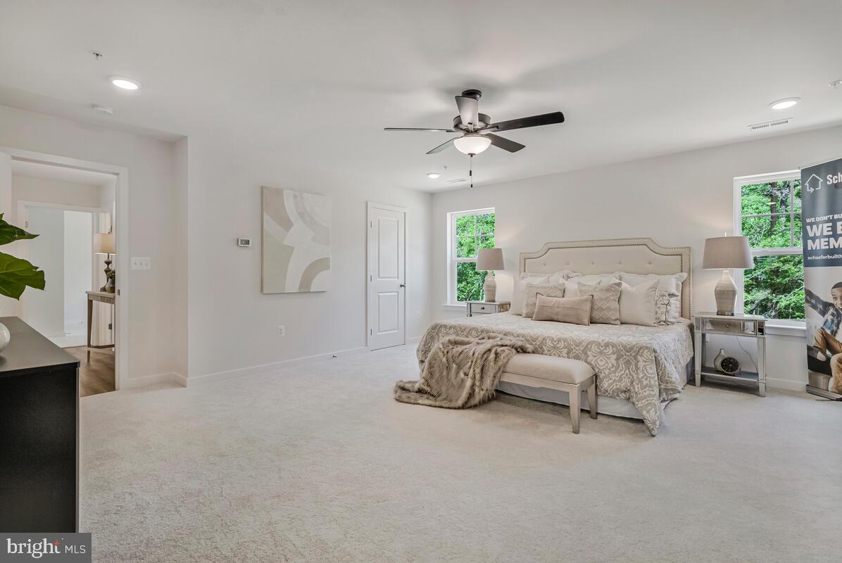 1302 Spruce Street Shady Side, MD 20764 - Photo 26 of 44 a spacious bedroom with a bed a couch and a chandelier