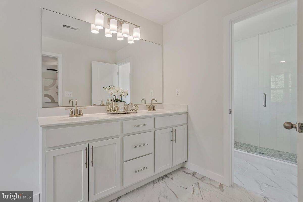 1302 Spruce Street Shady Side, MD 20764 - Photo 27 of 43 a bathroom with double sink and a mirror