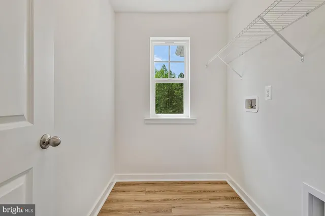 a view of a room with wooden floor and small window