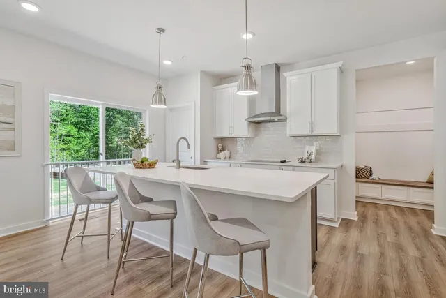 a kitchen with a sink a stove a dining table and chairs