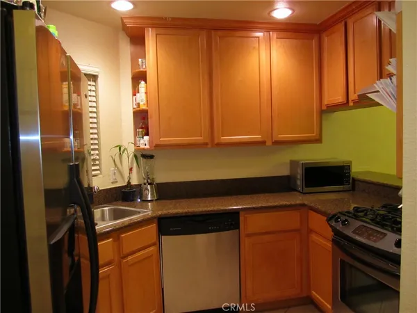 a kitchen with stainless steel appliances a stove a sink and a refrigerator