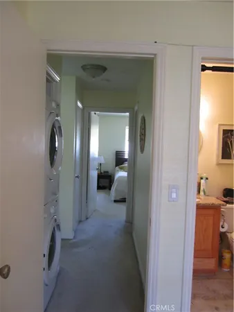 a view of a hallway with a livingroom and a mirror