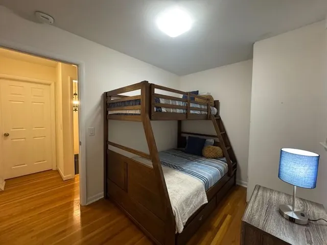 a bedroom with a bed and wooden floor