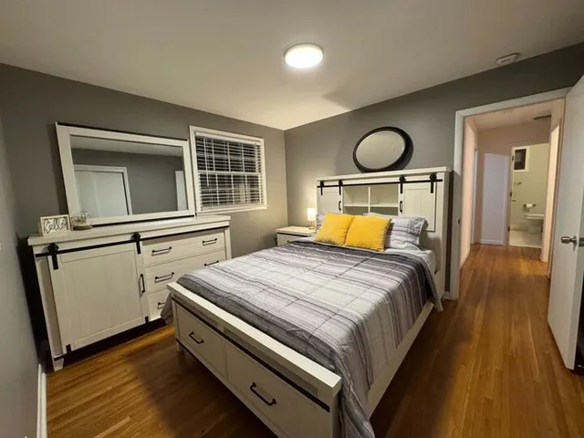 a bedroom with a bed and wooden floor