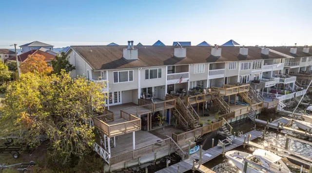 a kitchen with stainless steel appliances granite countertop a refrigerator a sink dishwasher a stove and white countertops with wooden floor