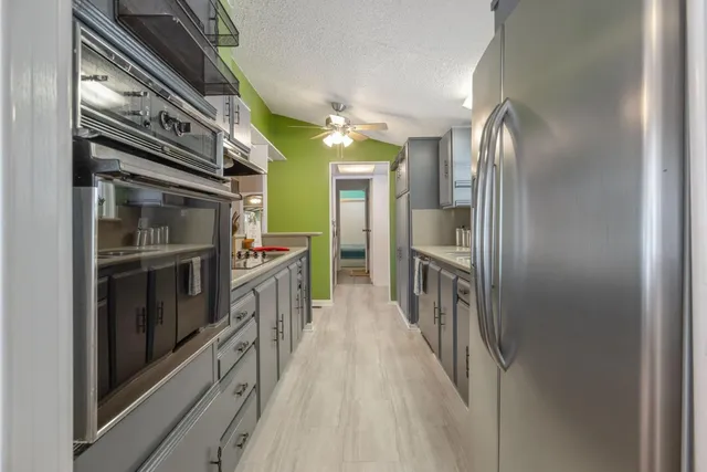 a kitchen with kitchen island a counter top space appliances and cabinets