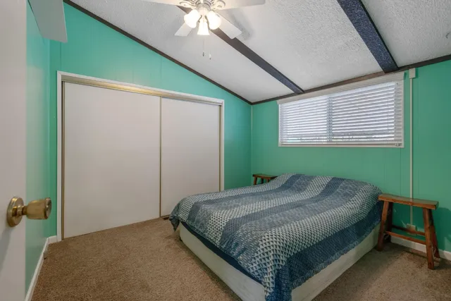 a bedroom with a bed and a large window