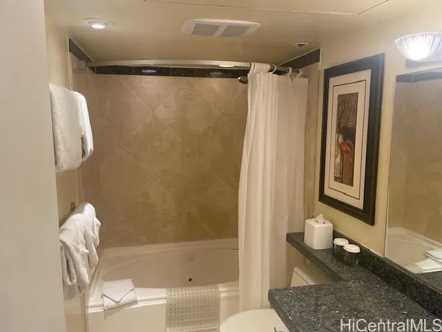 a bathroom with a granite countertop bathtub shower sink and toilet