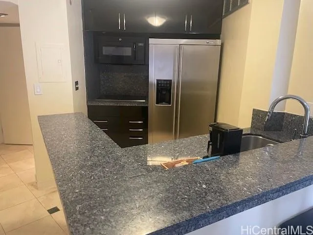 a kitchen with granite countertop a refrigerator and a sink