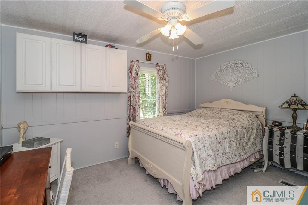 9 Morley Road, Unit 9 North Brunswick, NJ 08902 - Photo 12 of 19 a bedroom with a bed and a chandelier