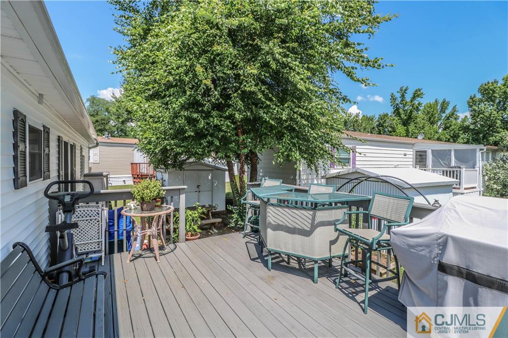 9 Morley Road, Unit 9 North Brunswick, NJ 08902 - Photo 14 of 19 a view of a patio with table and chairs a barbeque with wooden floor and fence