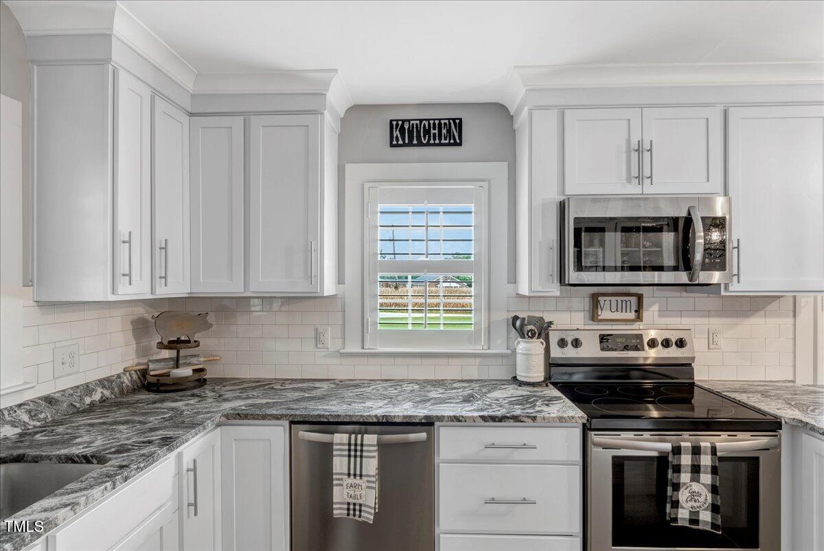1856 Flat Rock Church Road Louisburg, NC 27549 - Photo 12 of 30 a kitchen with granite countertop a stove sink and microwave
