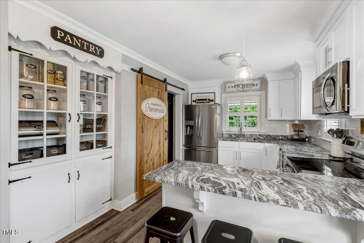 1856 Flat Rock Church Road Louisburg, NC 27549 - Photo 13 of 30 a kitchen with stainless steel appliances granite countertop a sink stove and refrigerator