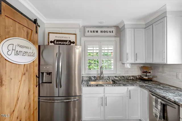 a kitchen with stainless steel appliances granite countertop a refrigerator and a sink