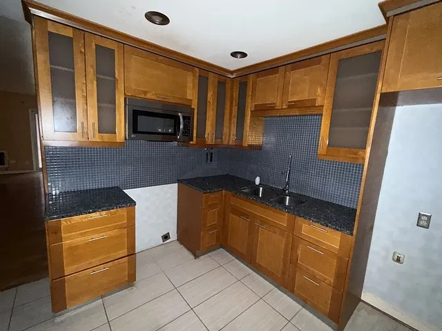 a kitchen with granite countertop cabinets stainless steel appliances and a counter top space