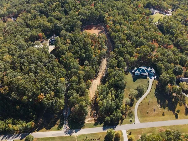 an aerial view of a residential houses with yard