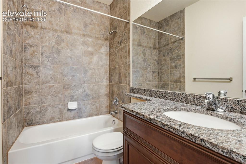 7806 Dutch Loop Colorado Springs, CO 80925 - Photo 16 of 41 a bathroom with a granite countertop sink toilet and shower