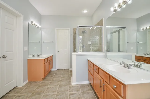 a bathroom with a double vanity sink a mirror and a shower