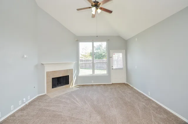 a view of empty room with window and fireplace