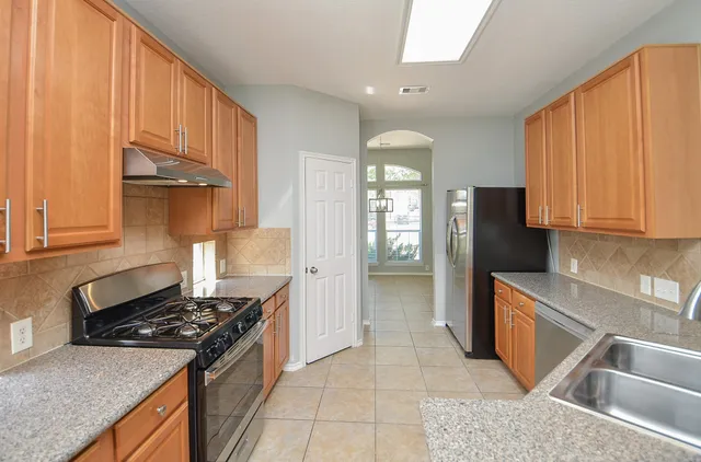 a kitchen with a sink stove top oven and cabinets