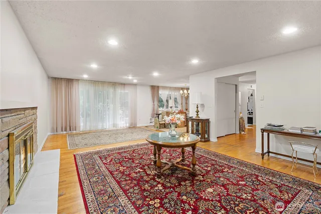 a living room with fireplace furniture and a rug
