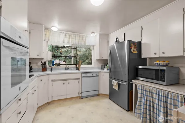 a kitchen with white cabinets and stainless steel appliances
