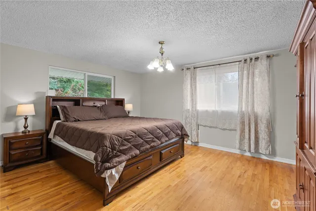 a spacious bedroom with a bed and a chandelier
