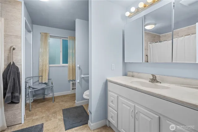 a spacious bathroom with a sink a toilet and a mirror