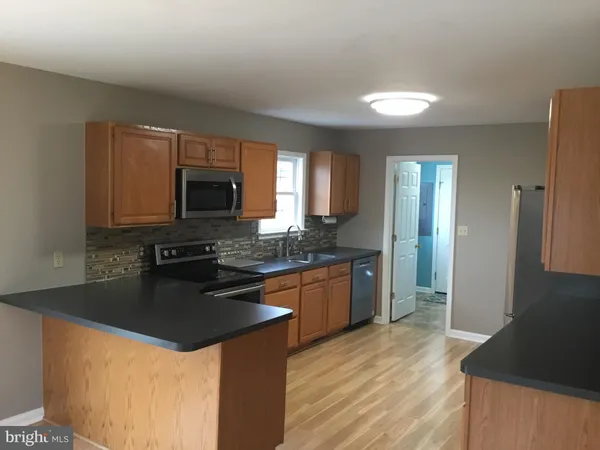 a kitchen with stainless steel appliances granite countertop a sink stove microwave and refrigerator