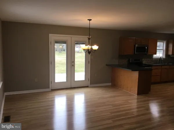 a kitchen with granite countertop a stove and a wooden floor