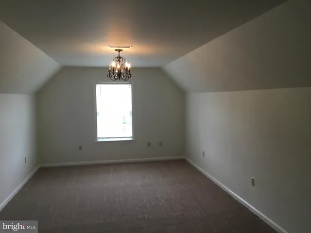 an empty room with a windows and chandelier