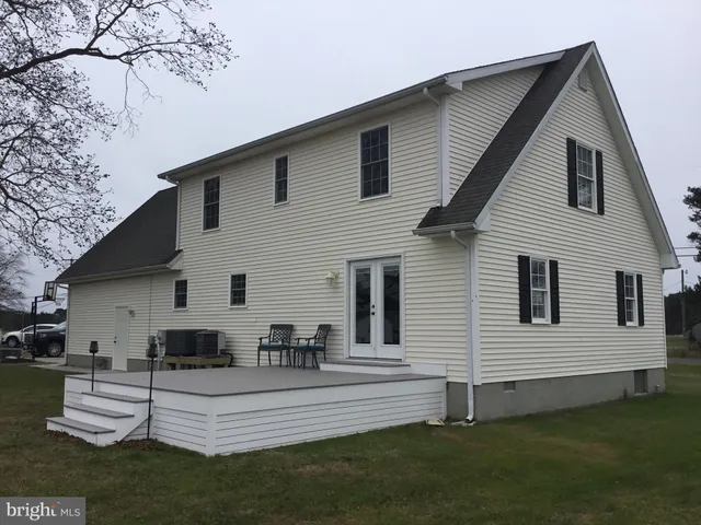 a view of a white house with a white wooden fence