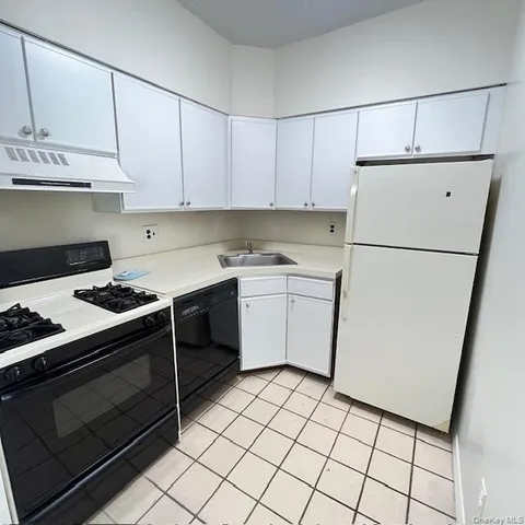 a kitchen with a stove sink and cabinets