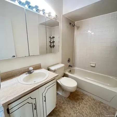 a bathroom with a sink a toilet a mirror a bathtub and shower