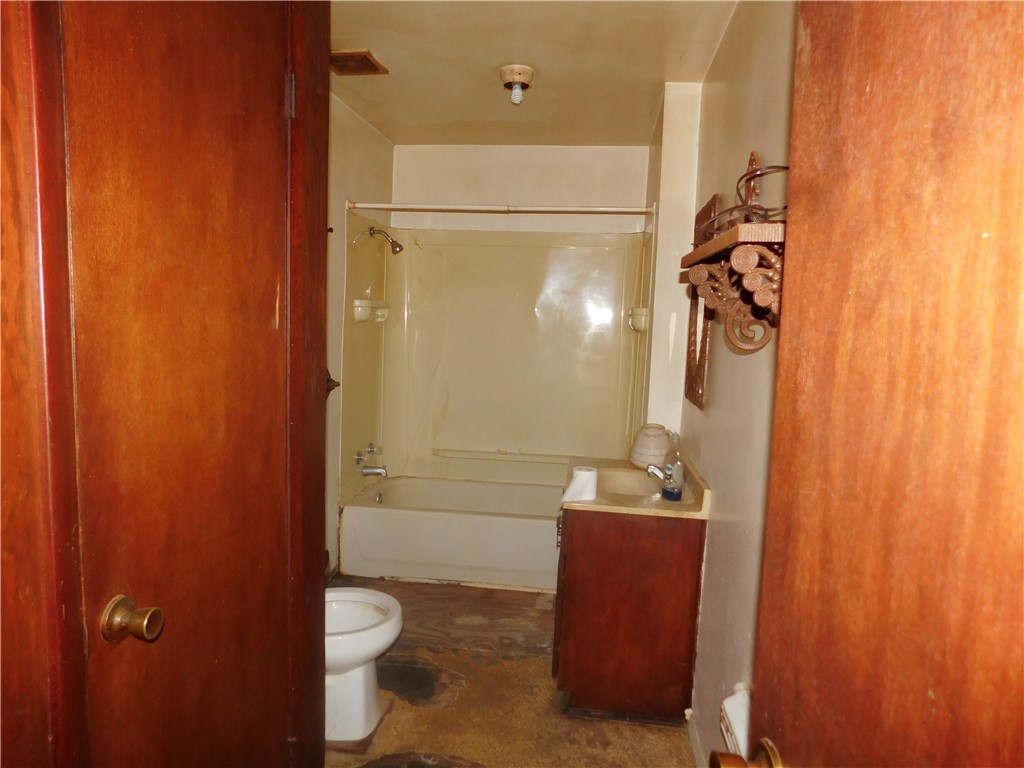 712 East 2nd Street Alice, TX 78332 - Photo 17 of 25 a bathroom with a granite countertop sink toilet and shower