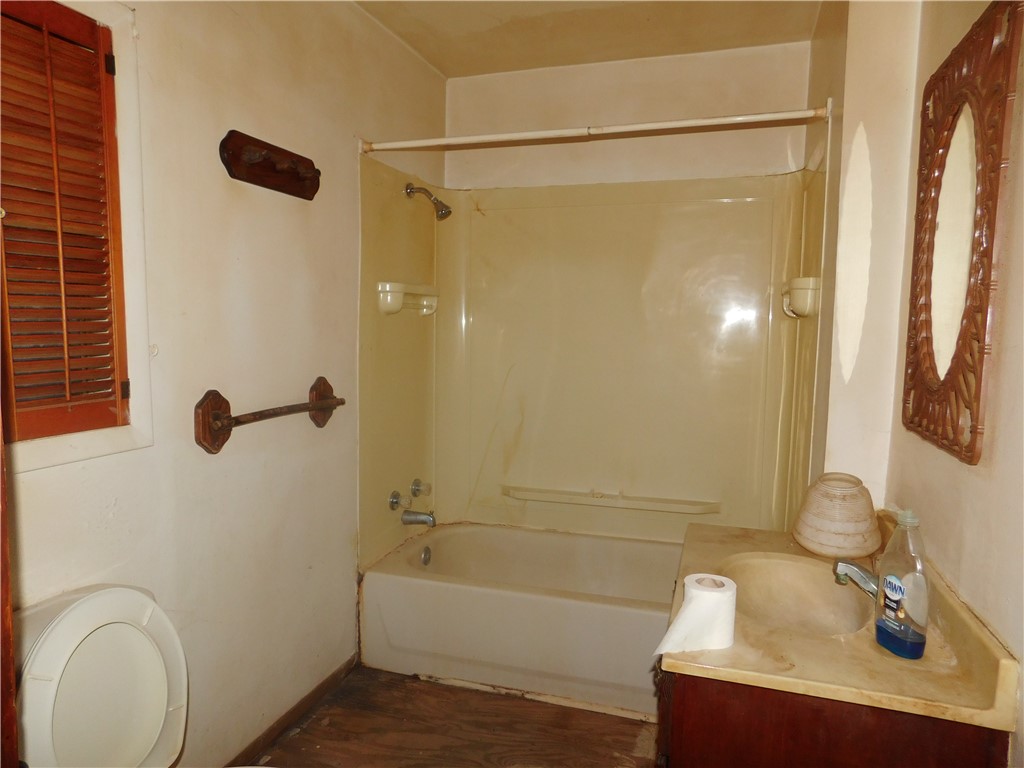 712 East 2nd Street Alice, TX 78332 - Photo 18 of 25 a bathroom with a sink a mirror a bathtub and shower