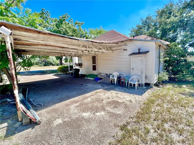 a view of a patio with table and chairs under an umbrella with a small yard