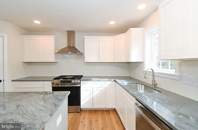 a kitchen with granite countertop a stove and a sink