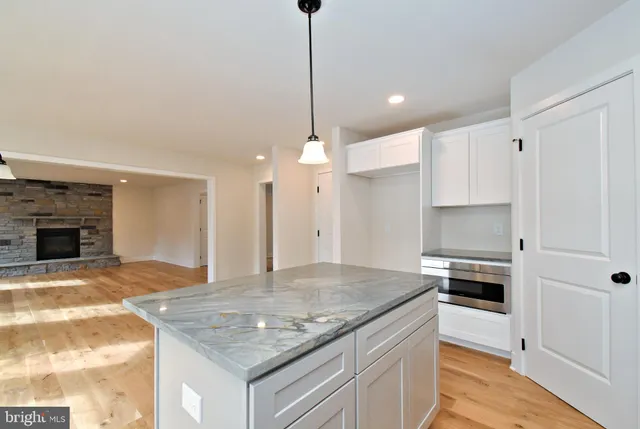 a kitchen with granite countertop a sink stainless steel appliances and white cabinets
