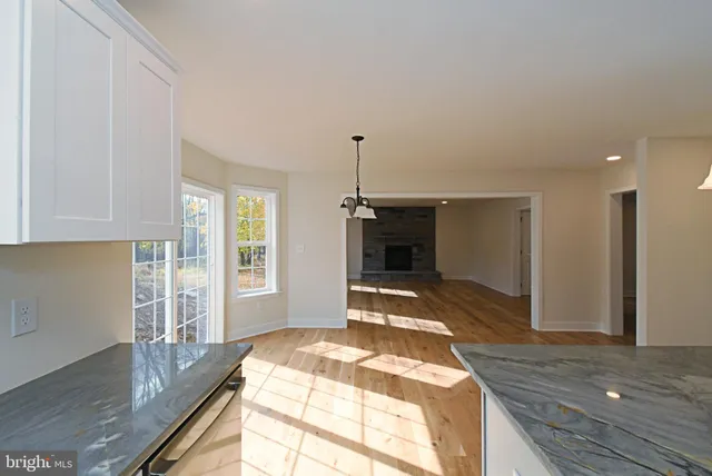 a kitchen with stainless steel appliances granite countertop a sink a stove and a granite counter tops with wooden floors