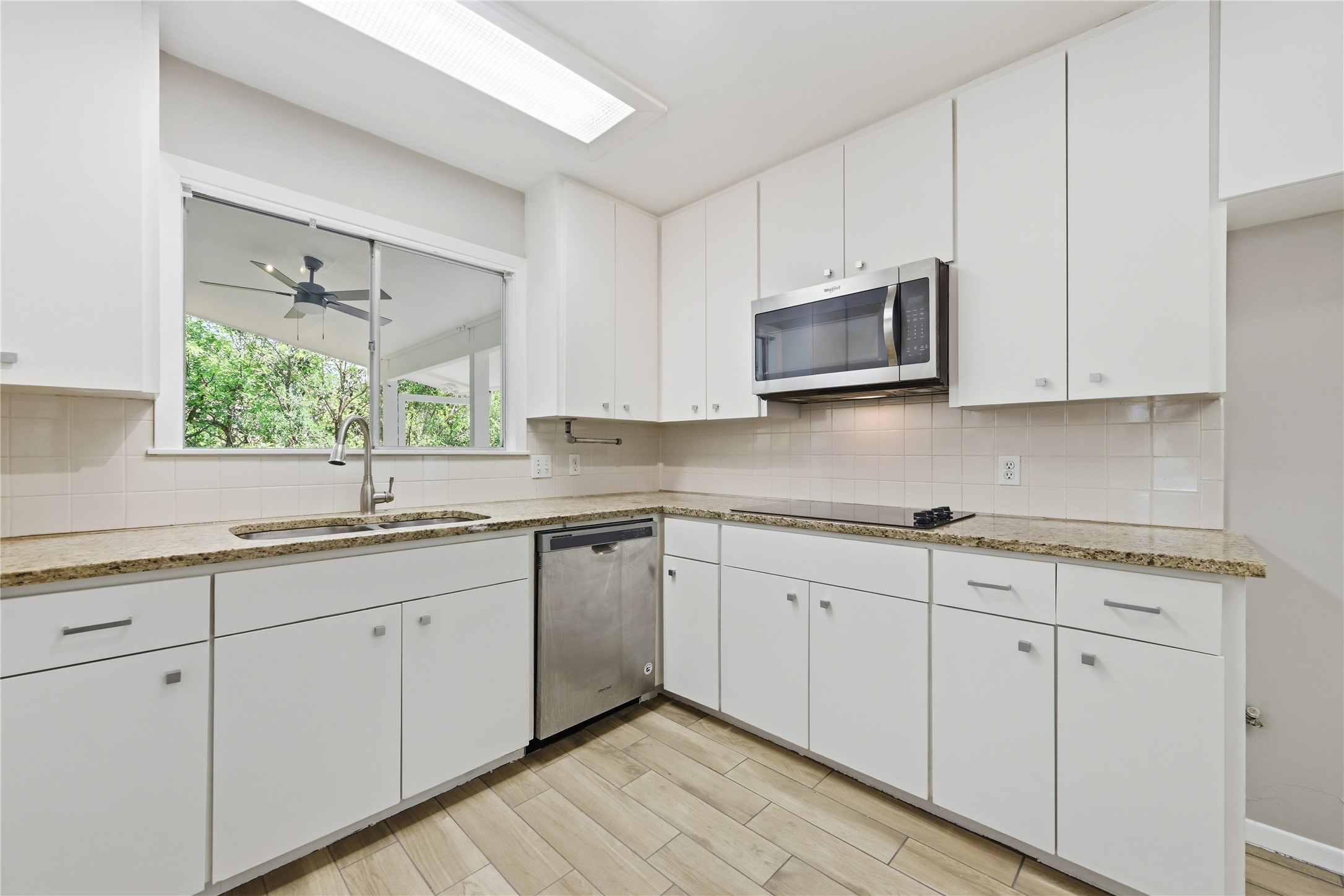 7 Hull Circle Austin, TX 78746 - Photo 7 of 17 A well-equipped kitchen features ample cabinetry and a window offering views of mature trees.