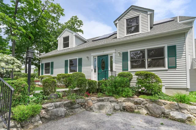 a front view of a house with garden and porch