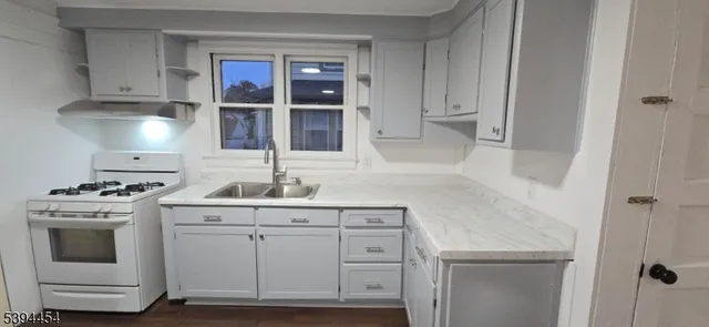 a kitchen with white cabinets and white appliances