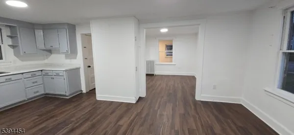a kitchen with wooden floors and white cabinets