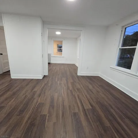 a view of a room with wooden floor and a window